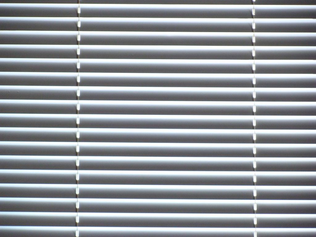 Innovatieve zonwering zonder boren in moderne woonkamer, zelfklevende raamfolie en klemmen voor eenvoudige installatie